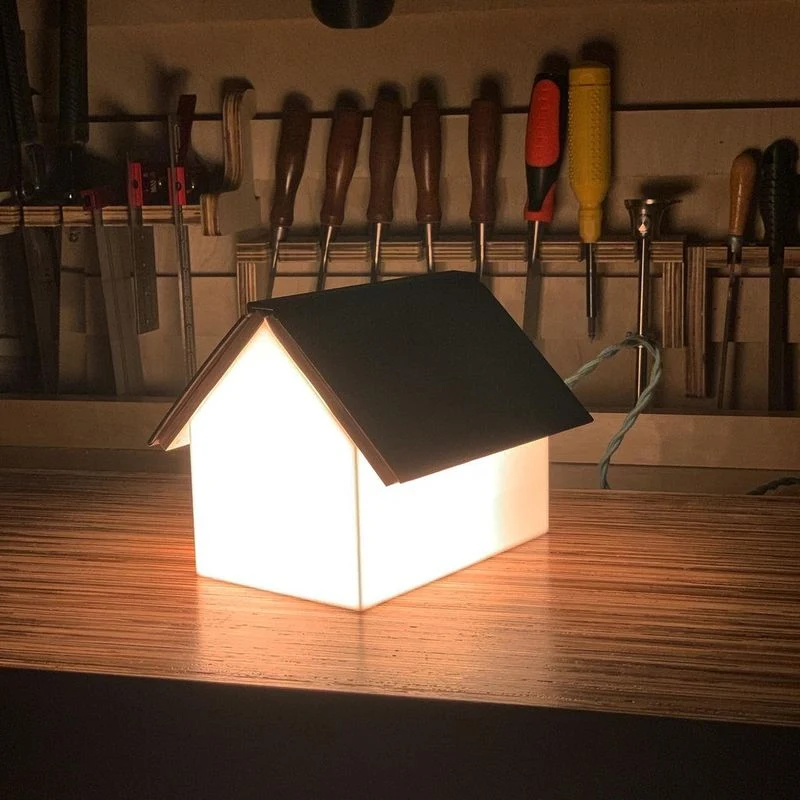 Printed housing listing on a pale desk with pencil underlines on several phrases, a ruler and a spare page of questions beside it, a small lamp lighting the paper from the left, 1400x933